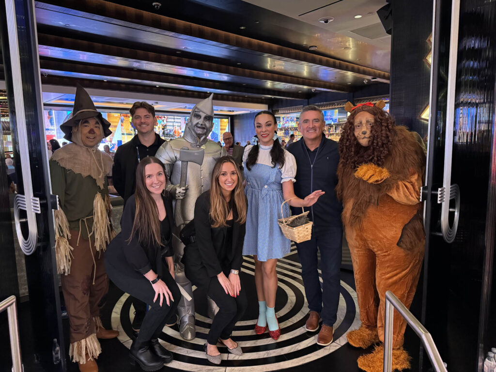 A group of people pose together indoors; some are dressed as characters from 