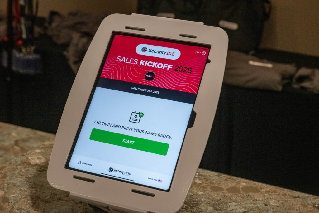 A touchscreen kiosk displays a check-in screen for the 