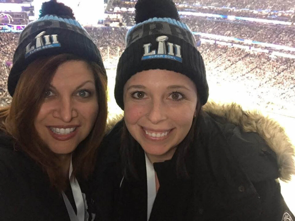Two women wearing black winter hats with 